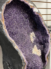 Large amethyst geode with calcite on stands – view 1