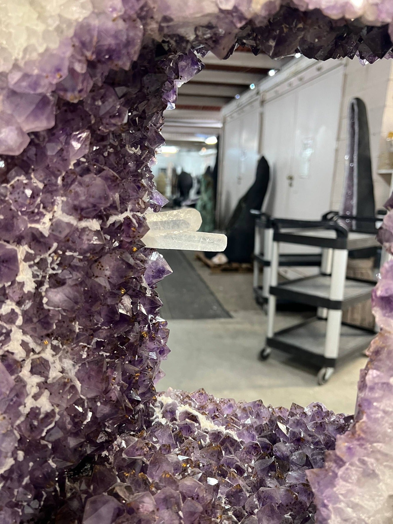 Beautiful Geode cut with clusters and points inside the amethyst tower on stand – Interior with calcite points